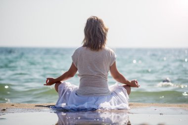 Denizde meditasyon yapan bir kadın