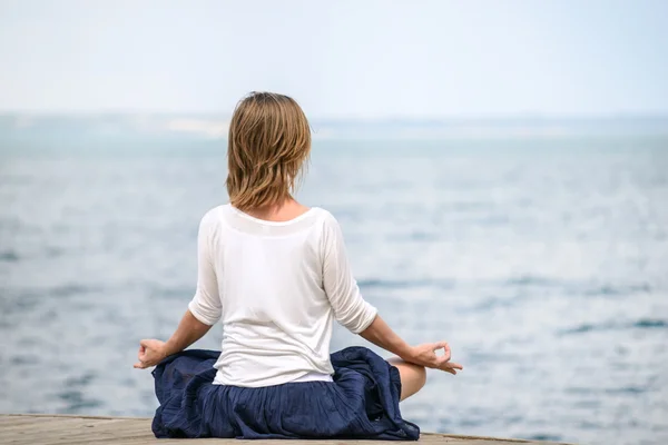 Mulher meditando no mar — Fotografia de Stock