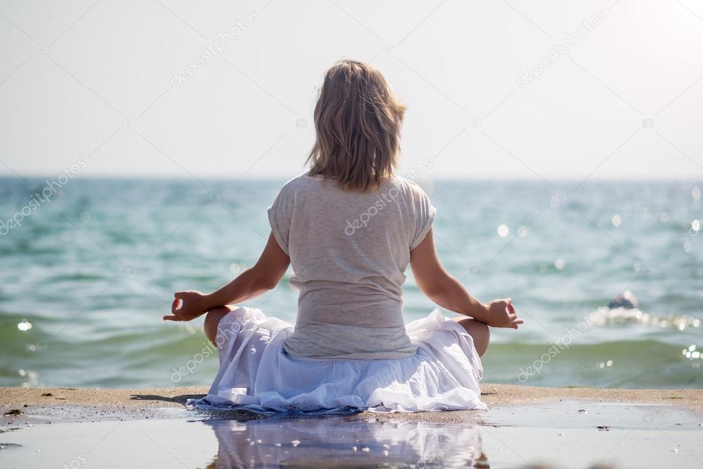 Woman meditating at the sea