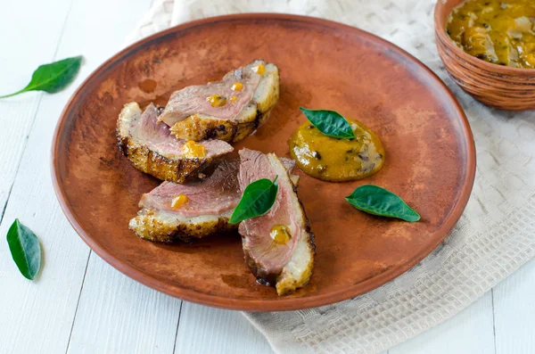 Roasted duck breast on a plate with sea buckthorn sauce — Stock Photo, Image