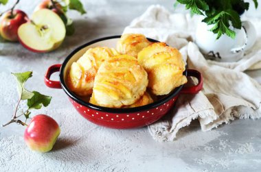 Gri arka planda bir kasede karamelli elmalı krep.