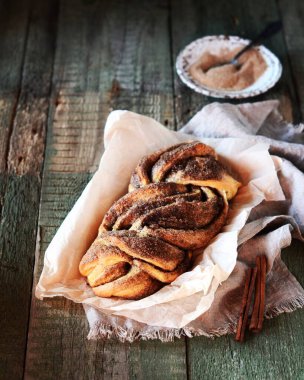 Tarçınlı somun ekmeği ya da siyah ahşap bir arka planda babka, durgun bir hayat, köy tarzı.