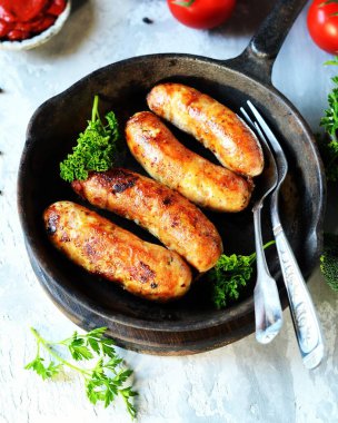 Kızartma tavasında kızartılmış hindinin ev yapımı sosisleri.