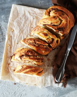 Tarçınlı somun ekmeği ya da siyah ahşap bir arka planda babka, durgun bir hayat, köy tarzı.