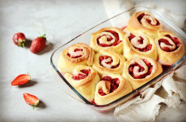 Gri arka planda çilekli ev yapımı maya çörekleri.