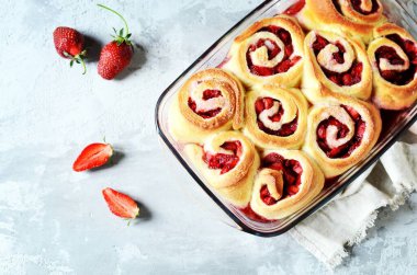 Gri arka planda çilekli ev yapımı maya çörekleri.