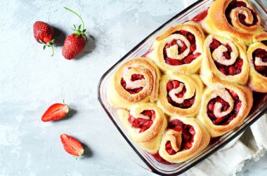 Gri arka planda çilekli ev yapımı maya çörekleri.