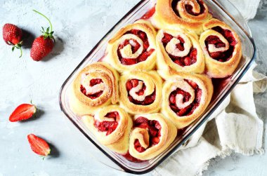 Gri arka planda çilekli ev yapımı maya çörekleri.