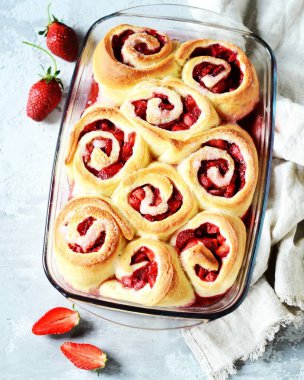 Gri arka planda çilekli ev yapımı maya çörekleri.