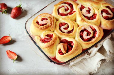 Gri arka planda çilekli ev yapımı maya çörekleri.