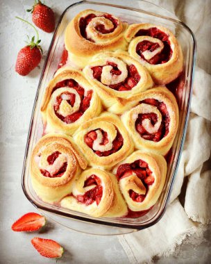 Gri arka planda çilekli ev yapımı maya çörekleri.