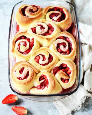 Gri arka planda çilekli ev yapımı maya çörekleri.