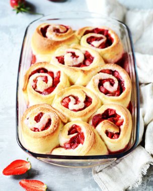 Gri arka planda çilekli ev yapımı maya çörekleri.