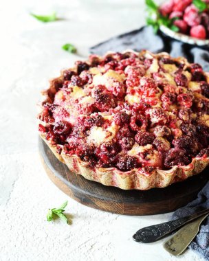 Ahududulu turta ve esmer şeker gri arka planda bir fırın kabında