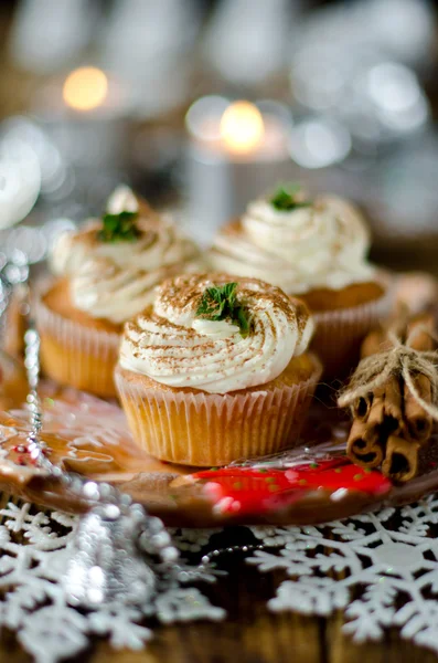 クリスマス カップ ケーキ クリスマス ツリーで飾られたテーブルの上のクリーム添え — ストック写真