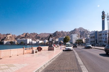 Tourist walking on Corniche, Muscat, Oman clipart