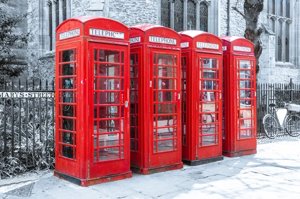 Row of red british telephone boxes on desaturated background — Stock Photo, Image