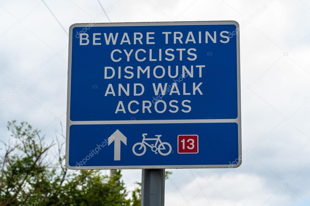 Railway crossing warning sign beware trains cyclists dismount and walk across