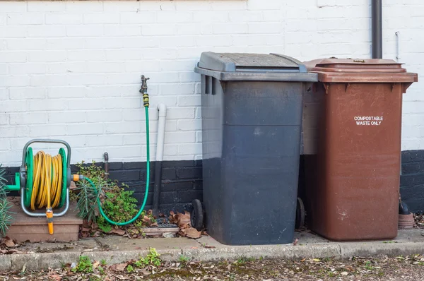 Переработка мусорных баков к стене — стоковое фото