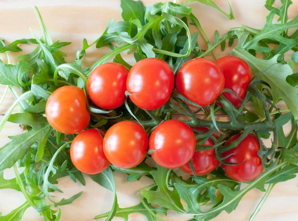 Tomates de cereja em um contexto de folhas de salada — Fotografia de Stock