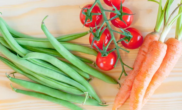 Judías verdes, tomates cherry, zanahorias bebé sobre fondo de madera —  Fotos de Stock