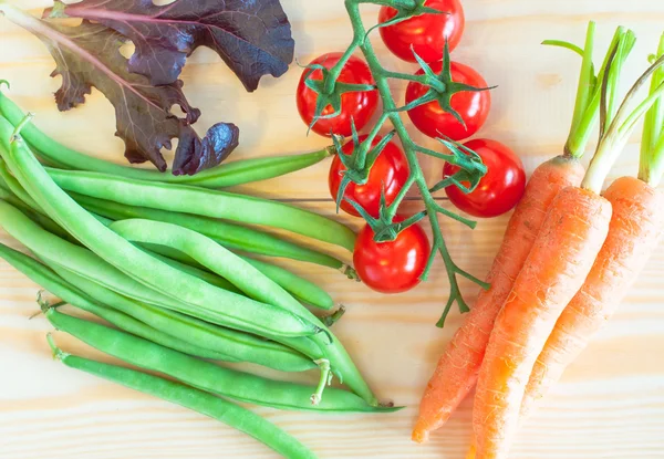 Haricots verts, tomates cerises, bébés carottes et feuilles de salade — Photo