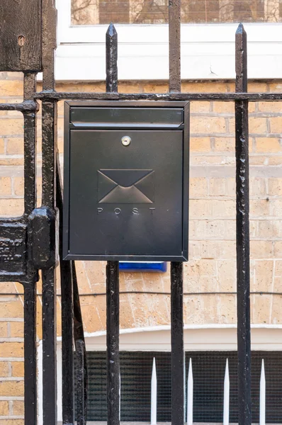 Metallic mailbox in black installed on the boundry fence. — Stock Photo, Image