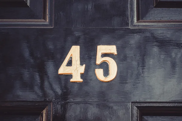 Дверь номер 45 на черной деревянной двери закрывается. — стоковое фото