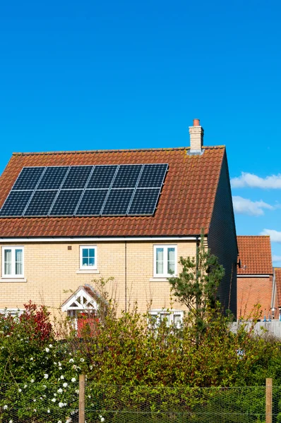 Panel solar fotovoltaico en el techo de la casa contra un cielo azul —  Fotos de Stock