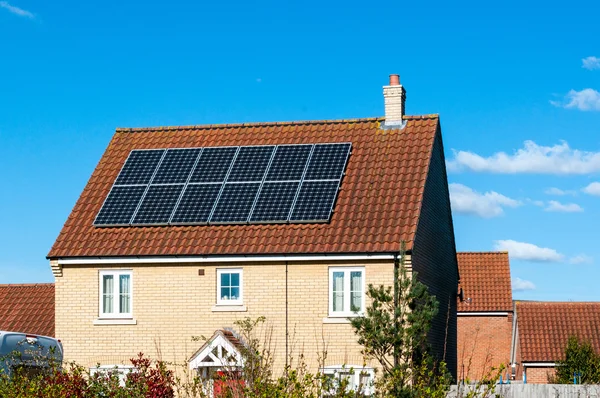 Panel solar fotovoltaico en el techo de la casa contra un cielo azul —  Fotos de Stock