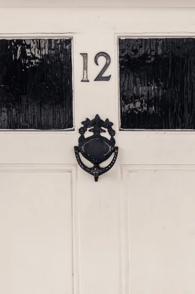 Door number twelve with door knocker — Stock Photo, Image