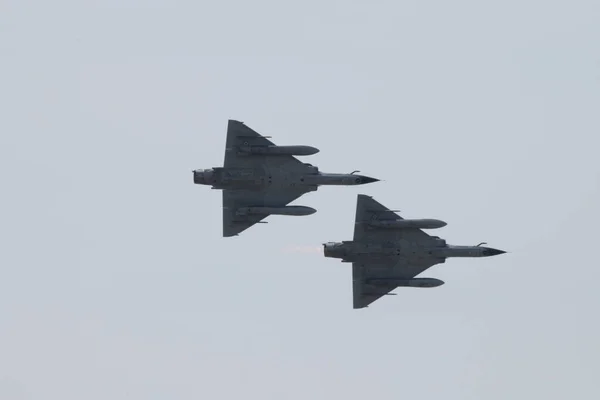2 Mirage 2000 savaş uçakları mavi gökyüzü ile uçuyor.
