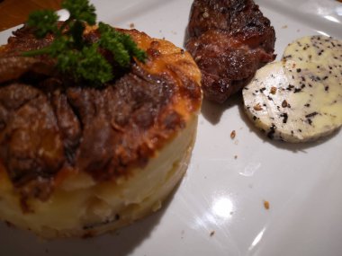 Graten Dauphinois, maydanoz, sığır eti ve yer mantarı ezmesi.