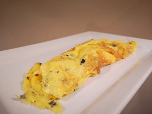 Dikdörtgen beyaz tabakta mantarlı omlet.