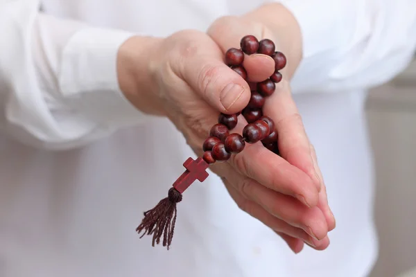 Mãos femininas em pose de oração com contas de rosário — Fotografia de Stock