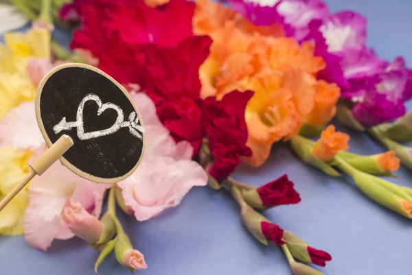 Love concept. Plate with heart on flowers backdrop — Stok fotoğraf