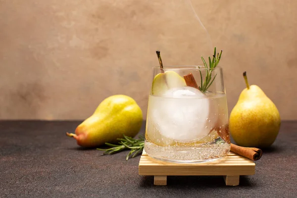 Cocktail rinfrescante di pere con tonico, cannella e rosmarino fresco su tavola di legno di ulivo con perle fresche e dolci.. — Foto Stock