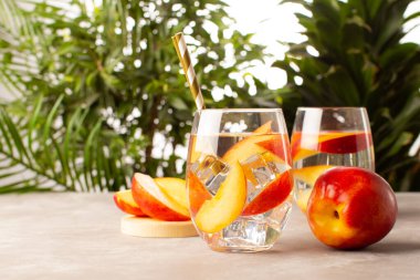 Şeftali kokteyli ya da taze şeftali ve tropikal bitkilerle dolu limonata. Taze yaz kokteyllerine yakın durun..