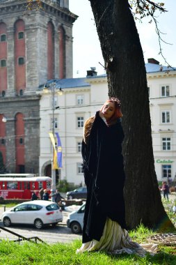 Taş bir kalenin, metal bir kapının ve hapishane penceresinin önündeki kaldırım taşlarının üzerindeki seksi, uzun saçlı genç kız.