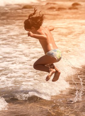 Çocuk kumsalda atlama