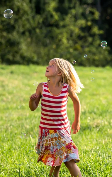 Little girl blowing soap bubbles — Stock Photo, Image