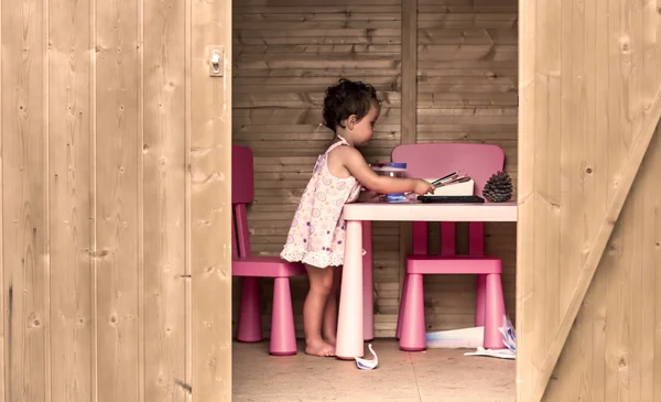 Chica pintando en una cabaña de madera —  Fotos de Stock