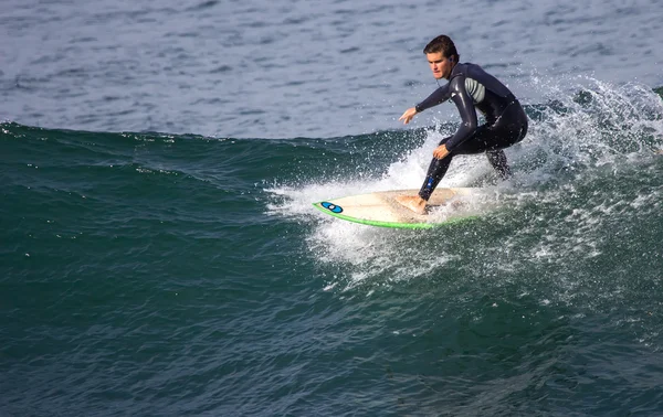 Athlete surfing on San Lorenzo beach — Stock Photo, Image