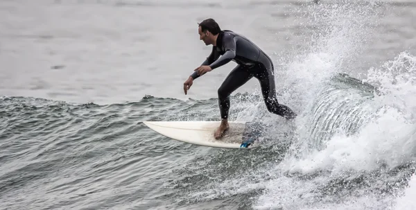 L'uomo che fa surf su un'onda nel mare — Foto Stock