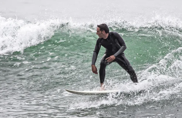 Человек сёрфингирует волну в море — стоковое фото