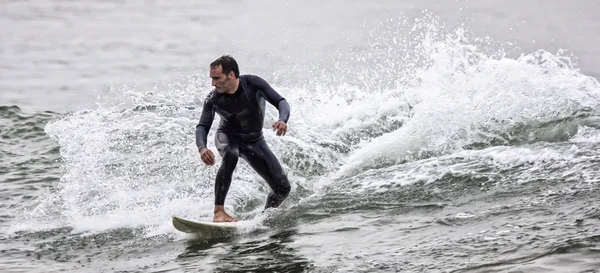 Mies surffaa aalto meressä — kuvapankkivalokuva