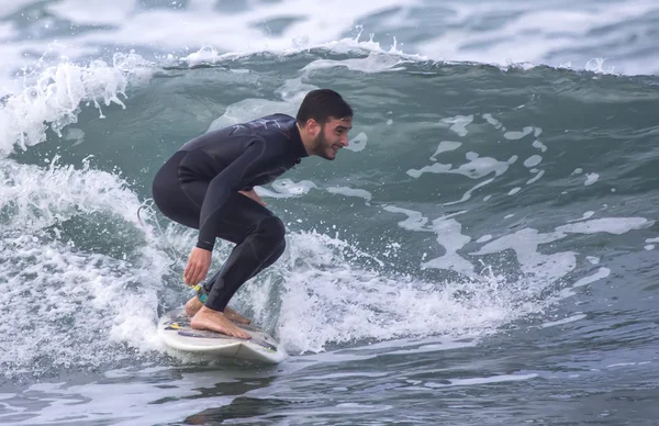 Человек сёрфингирует волну в море — стоковое фото