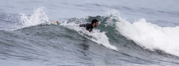 L'uomo che fa surf su un'onda nel mare — Foto Stock