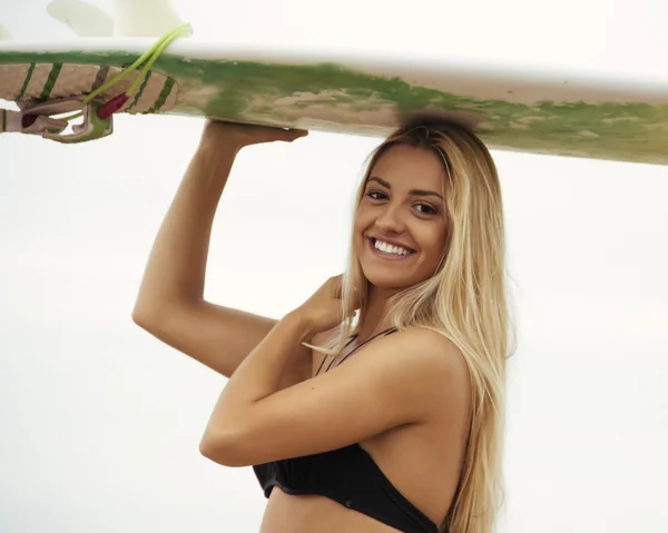 Girl innehar surfbräda på stranden — Stockfoto