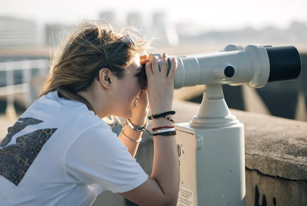 Adolescente usando um telescópio turístico — Fotografia de Stock